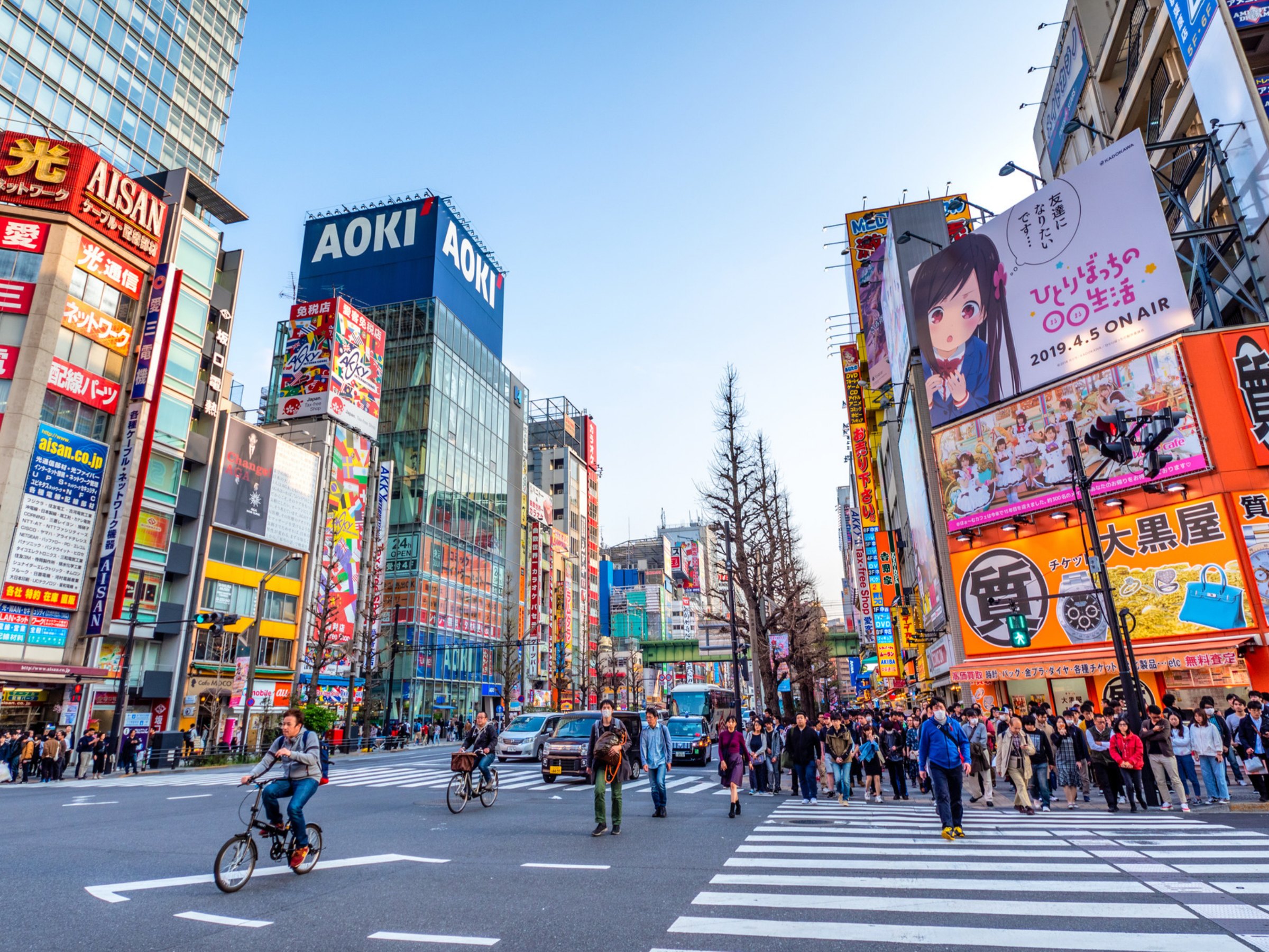 Busy city street crossing lined with colourful billboards
