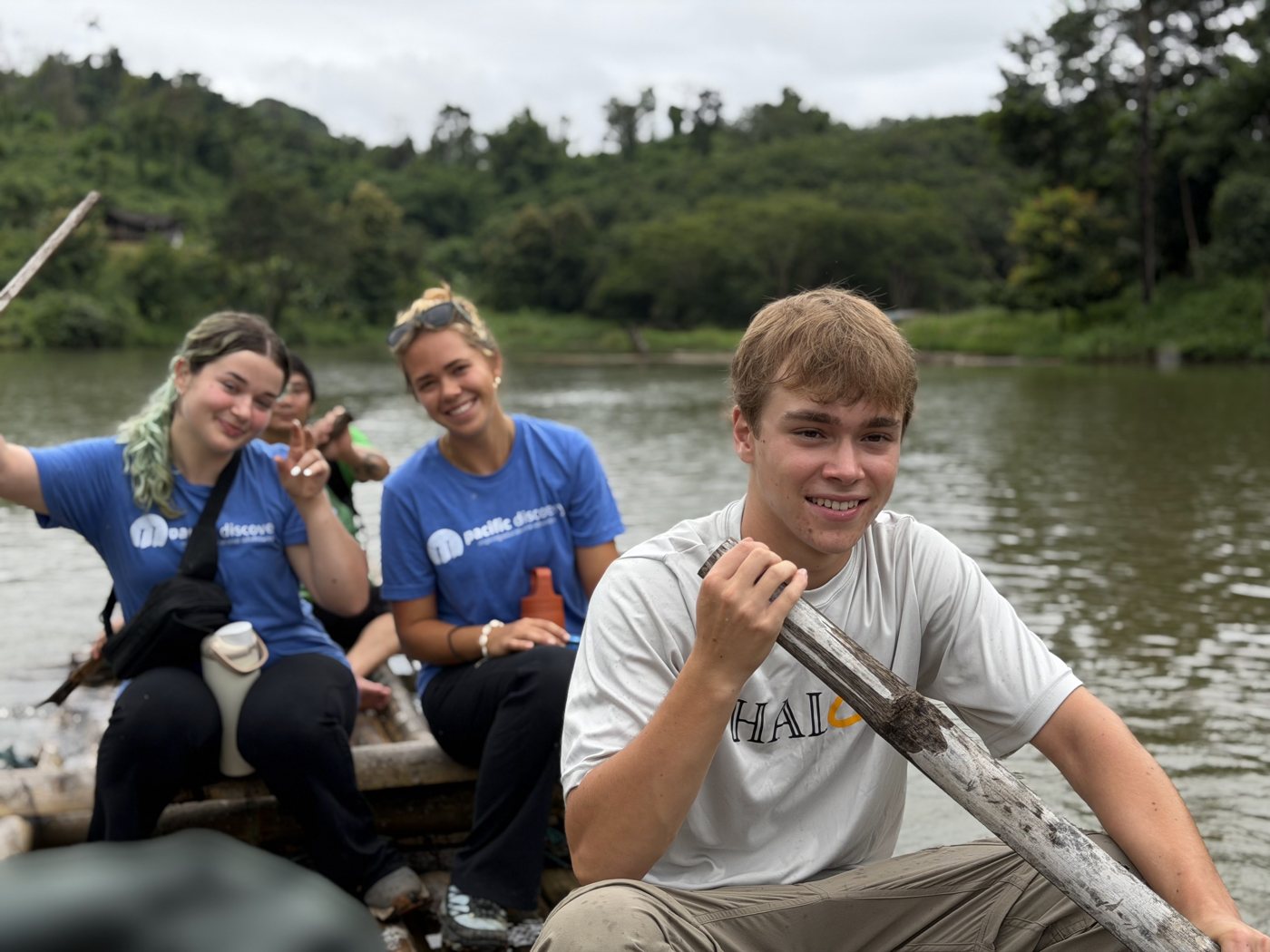 Students laughing on a bamboo raft